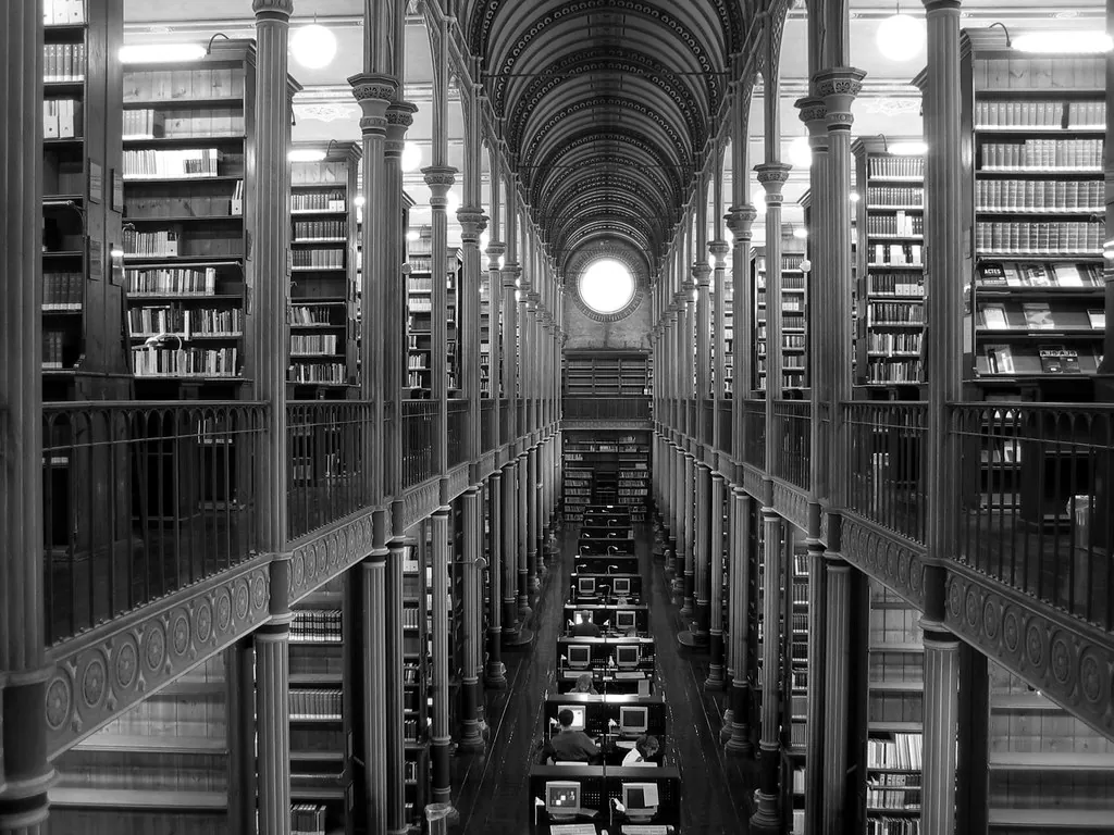 Galería de una biblioteca antigua con estanterías de varios pisos