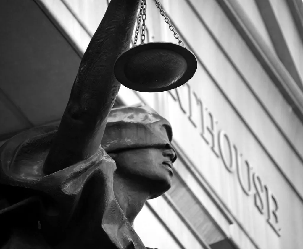 Estatua de la Justicia con la balanza en la fachada de un tribunal